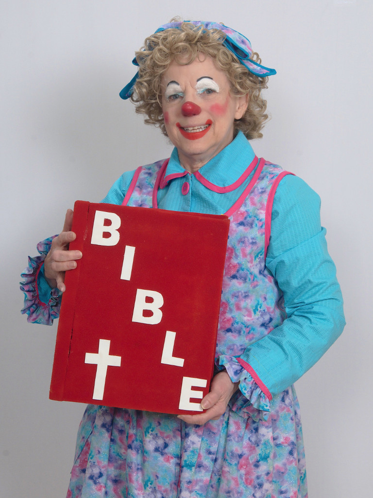 Rainbow the Clown holding an oversized Bible