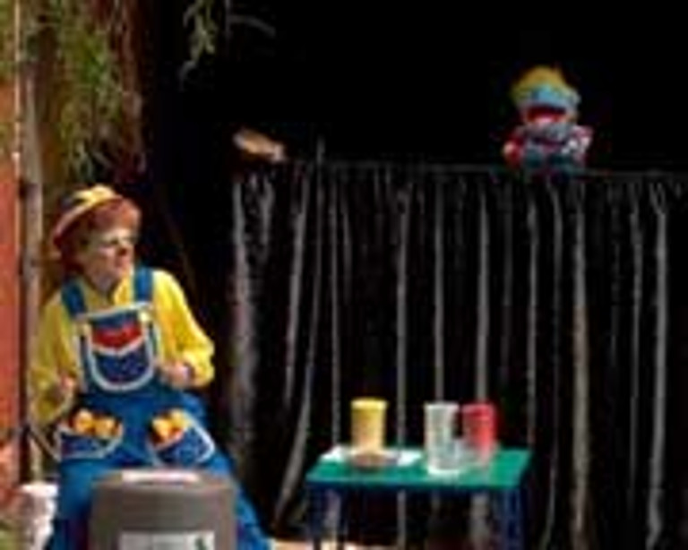 Rainbow plays a drum while a puppet sings