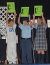 Three children hold up signs showing 9-1-1