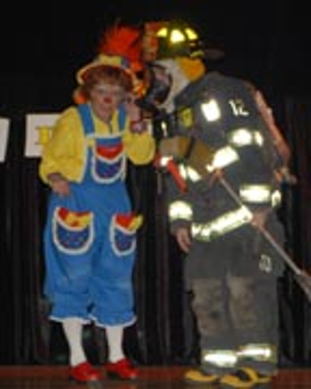 A firefighter in full gear talks to Rainbow